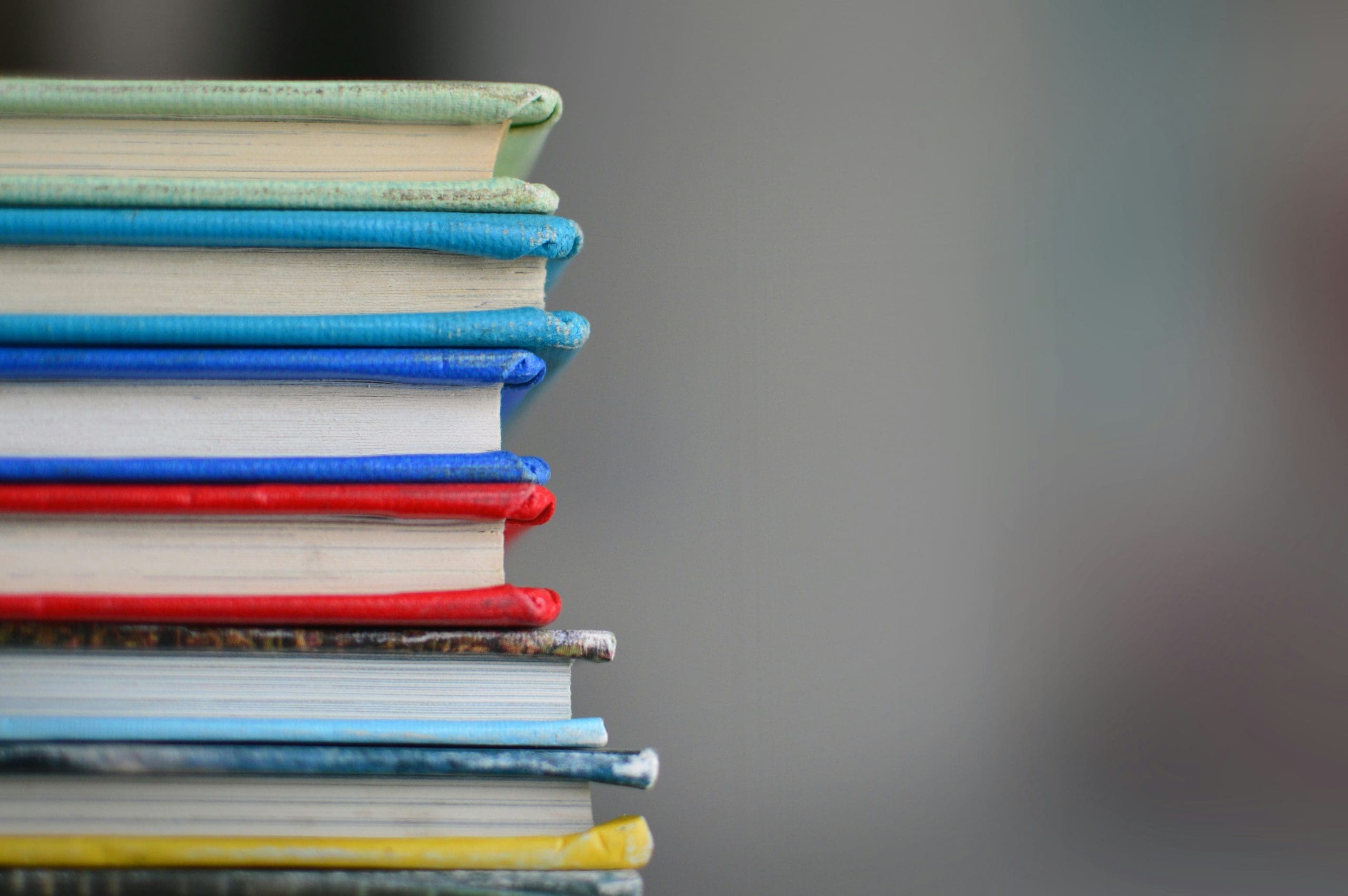 Stack of colorful books with blue, red, and yellow covers, photo.