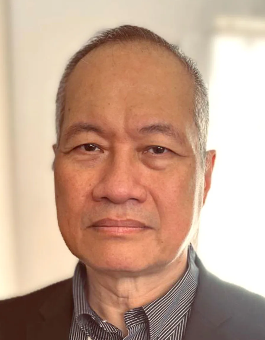 Man in a suit, neutral expression, indoor lighting, photo, no text.