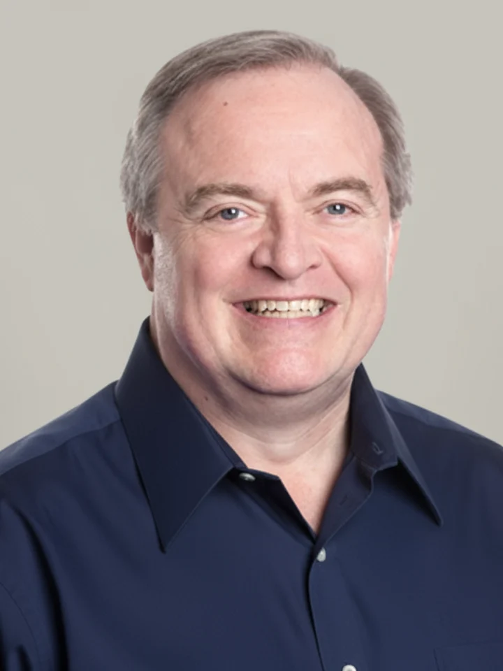 Smiling man in a navy shirt, neutral background, portrait photo style.